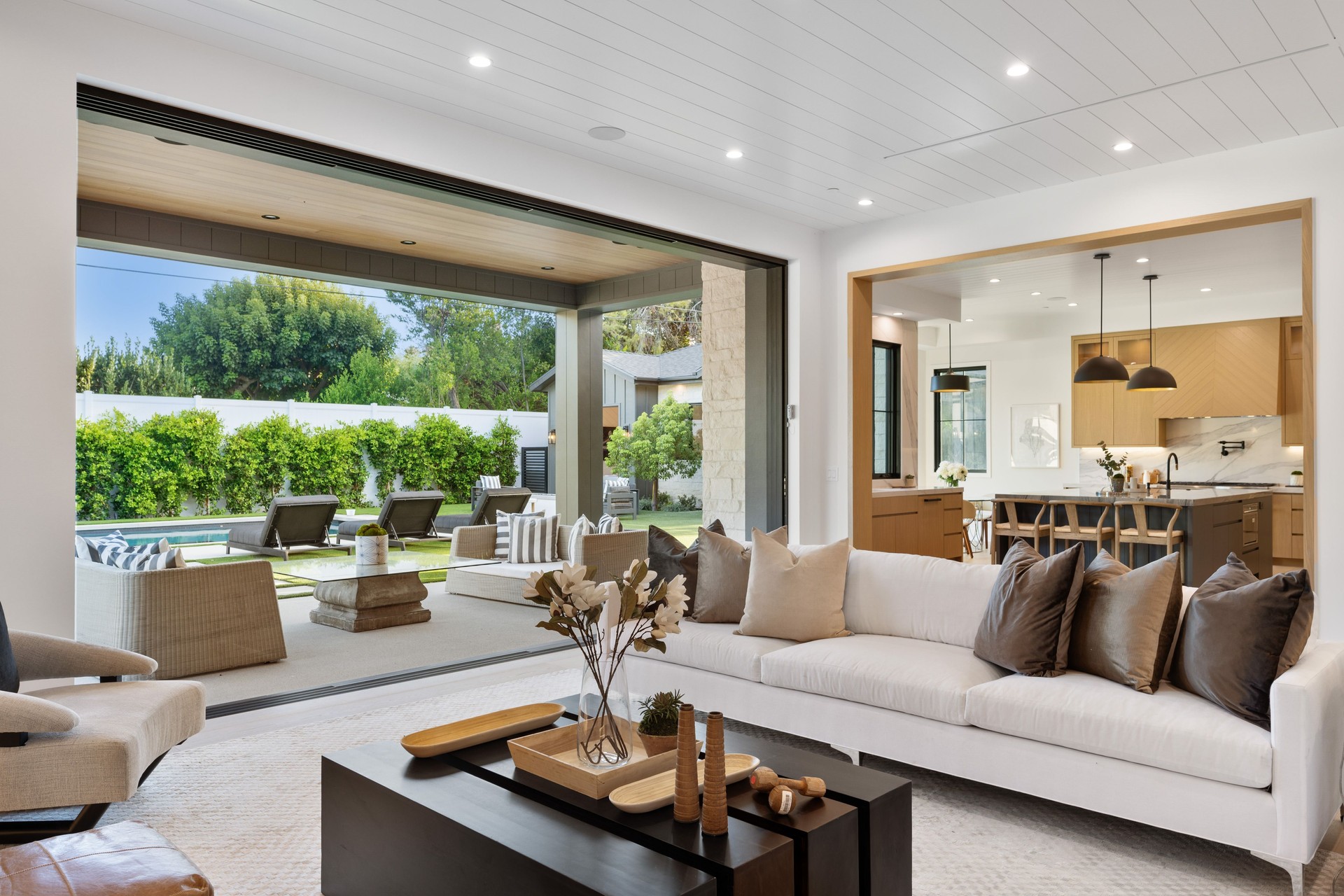 Modern living room with open sliding doors to patio and garden.